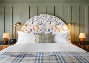 a bedroom with a white bed with a floral headboard at Le Petit Pali at Ocean Ave in Carmel