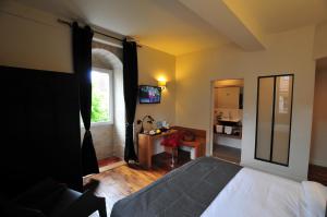 Schlafzimmer mit einem Bett, einem Fenster und einem Tisch in der Unterkunft SY-la terrasse in Vézelay