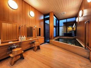 a bathroom with a tub with a toilet and a sink at Ryokan Tanabe 旅館田邊 in Takayama +77 photos