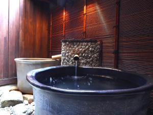 a large bath tub with a water fountain at Ryokan Tanabe in Takayama