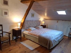アルティガにあるFerme Beauregard Les Pyrénéesの木製の天井が特徴のベッドルーム1室(大型ベッド1台付)