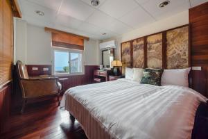 a bedroom with a bed and a desk and a window at H& Jiufen The Dragon Inn in Jiufen