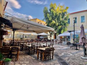 an outdoor patio with tables and chairs and umbrellas at Castle Maisonette in Chios