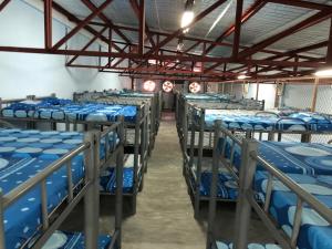 a room filled with lots of blue bunk beds at Mang Ben Dormitory Kaliraya in Manila