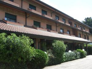 un gran edificio con arbustos delante de él en Hotel Canturio, en Cantù