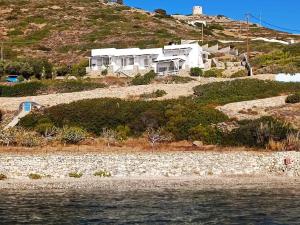 a house on top of a hill next to the water at Alezina studios in Amorgos