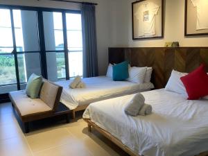 um quarto de hotel com duas camas e uma cadeira em K&B Happy Villa em Tainan