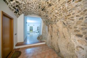 a hallway with a stone wall with an archway at Il Nido dell'Artista - Happy Rentals in Tenno