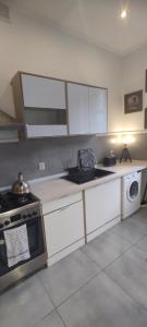 a kitchen with white cabinets and a stove top oven at Liberation!! in Olsztyn