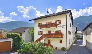 ein Gebäude mit einem Balkon mit Blumen darauf in der Unterkunft Ferienwohnung Jonagold Schnalserhof in Latsch