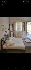 Un dormitorio con una gran cama blanca y una ventana en Alezina studios, en Amorgós