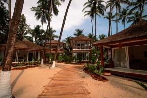 un complejo en la playa con palmeras en Thalassa Beach Boutique Resort en Goa Velha