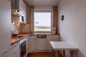 een keuken met een raam en een tafel. bij Haus Halligblick Whg 15 in Wyk auf Föhr