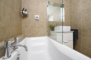 a bathroom with a sink and a bath tub at Huge & Central 3 Bedr, 4 Beds, Covent Gdn in London