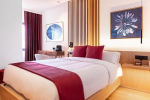 um quarto com uma cama grande e almofadas vermelhas em Boutique Hotel OLOM - Only Adults recommended em Cádiz