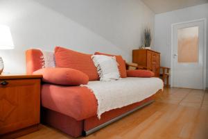 a couch with orange pillows on it in a room at Grunwaldzka 104 in Pobierowo