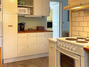 a kitchen with a white stove and a microwave at Holiday home LINKÖPING II in Linköping