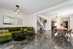 Una sala de estar con un sofá verde y una mesa. en Villa LA ZE, en Rogoznica