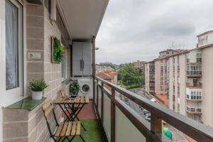 balkon z 2 krzesłami i pralką w obiekcie Amplio y Luminoso en Leioa w mieście Leioa