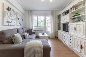 salon z kanapą i telewizorem w obiekcie Amplio y Luminoso en Leioa w mieście Leioa