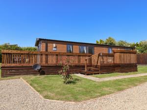 a wooden house with a fence and a yard at Marigold Lodge in Saltburn-by-the-Sea