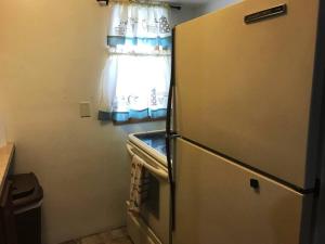 a refrigerator in a small kitchen with a window at A Quaint, Private 1 Bdrm Apt in South Bend
