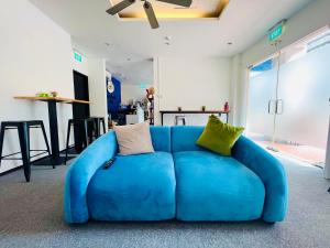 eine blaue Couch mit Kissen in einem Zimmer in der Unterkunft Beary Best! Hostel Chinatown in Singapur