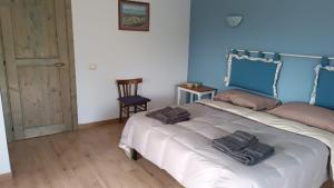a bedroom with a large white bed with blue walls at Stellaria casa vacanze in montagna panorama stupendo Sardegna in Seùlo