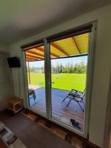 a room with a sliding glass door with a deck at Urlopownia-Domki z Indywidulanym Ogrodzeniem-Dogfriendly-Duży,Zielony Teren in Gąski