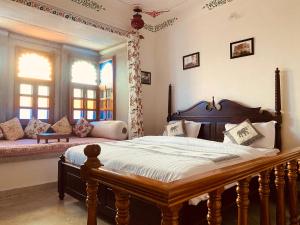 a bedroom with a large bed and a couch at Haveli Gokul Niwas, Talawada Near Sitamata SAnctuary, Chittorgarh. in Lunda