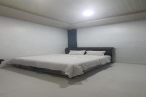 - une chambre blanche avec un lit dans l'établissement OYO 92578 Sri Ulina Homestay, à Medan