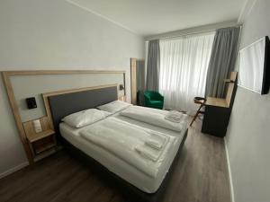 ein Schlafzimmer mit einem großen weißen Bett und einem Fenster in der Unterkunft Stadthotel Hamburg in Hamburg