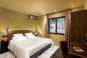 Un dormitorio con una cama grande y una ventana. en Maison Thérèse by Panorama Locations - SPA privatif, en Carcassonne