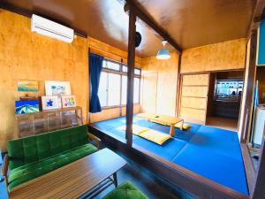 uma sala de estar com um sofá verde e uma mesa em 青とサイダー em Oshima