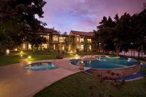 an exterior view of a resort with two pools at Waterwoods Lodge Kabini in Begūr