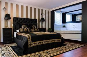 a bedroom with a black bed and a bath tub at Belle Le Vie in Sassafras