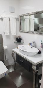 a bathroom with a white sink and a mirror at Mandarin hotel beach view in Jaffa Tel Aviv