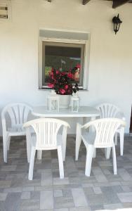 サルティにあるRooms & Studios Christinaの白いテーブルと椅子2脚、花瓶