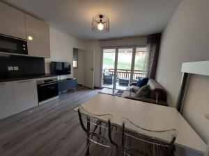 cocina y sala de estar con mesa y sillas en Appartement sur Valberg dans résidence neuve proche centre, en Valberg