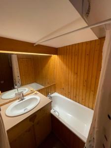 un baño con lavabo y bañera en Les Thermes 25 Le Mont Dore, en Le Mont-Dore 3 fotos más