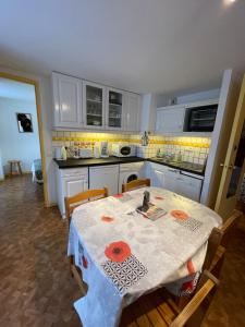 cocina con mesa, mesa y sillas en Les Thermes 25 Le Mont Dore, en Le Mont-Dore