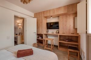 a bedroom with a bed and a desk with a tv at Living Moments in Fira +88 photos