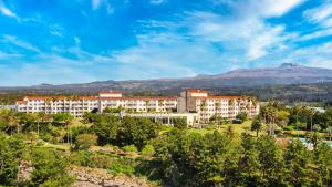 a view of a resort with mountains in the background at Kensington Resort Seogwipo in Seogwipo
