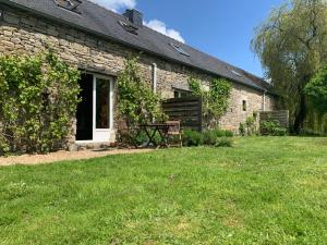 a stone house with a picnic table in the yard at Domaine de la Blanche Hermine in Plounérin