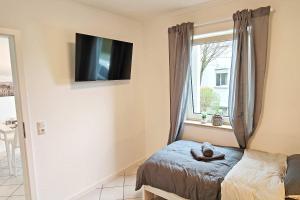 a bedroom with a cat laying on a bed next to a window at Chic Apartments in Altenstadt in Altenstadt