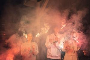 a group of three people holding fire sparklers at itotoi本邸 in Itoshima