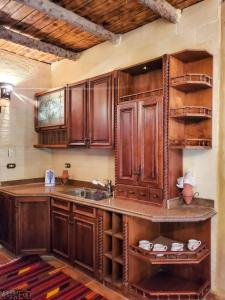 a kitchen with wooden cabinets and a sink at Paloma Lodge in Siwa