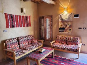 a living room with two couches and a table at Paloma Lodge in Siwa