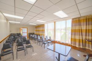 una sala de conferencias con sillas, mesas y una ventana en Masters Inn Selma Smithfield I-95 By OYO, en Selma