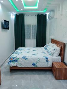 a bedroom with a bed with green lights on it at Studio Emeraude - cosy et climatisé - Résidence Saraba Mermoz in Dakar
